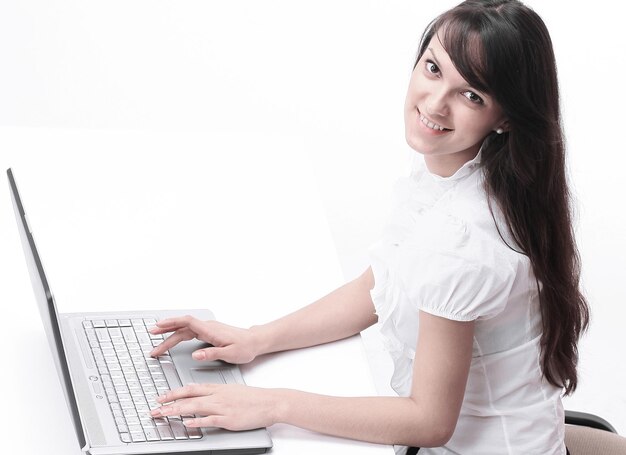 Mujer joven escribiendo texto en el teclado de la computadora portátil