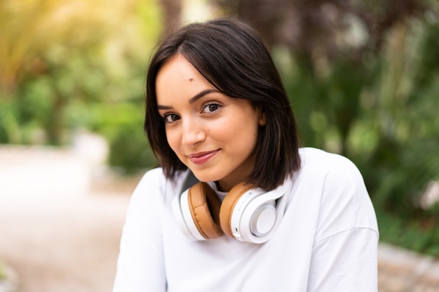 Mujer joven escuchando música al aire libre