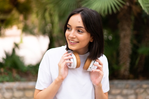 Mujer joven escuchando música al aire libre