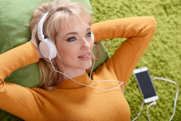 Mujer joven escuchando música en auriculares