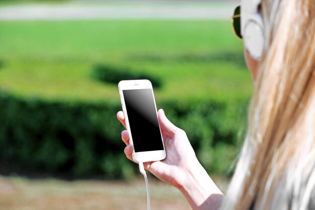 Mujer joven escuchando música y caminando por la calle