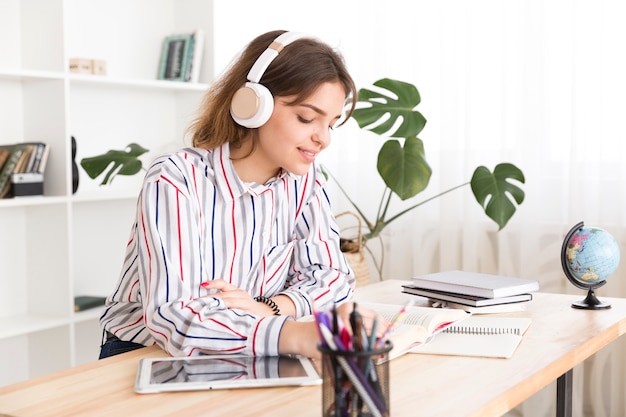 Mujer joven escuchando música y leyendo