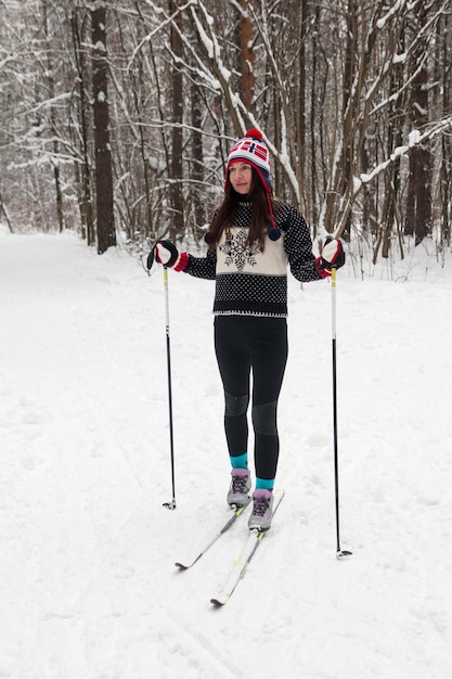 Mujer joven esquiando en el parque Bosque de invierno blanco y esquiador