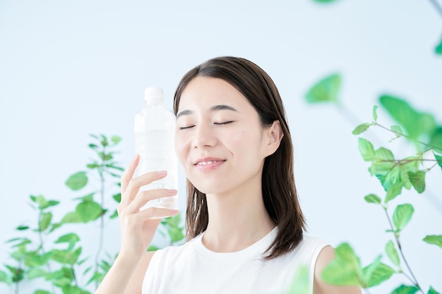 La mujer joven está bebiendo agua