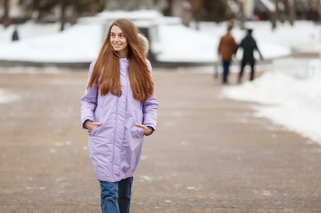 Mujer joven está caminando en el parque de invierno