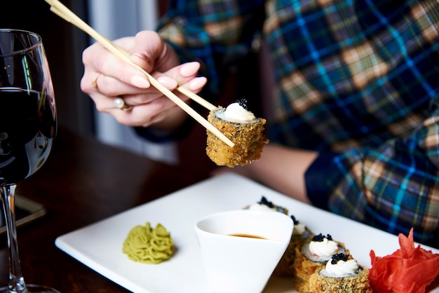 Una mujer joven está cenando en un restaurante japonés.