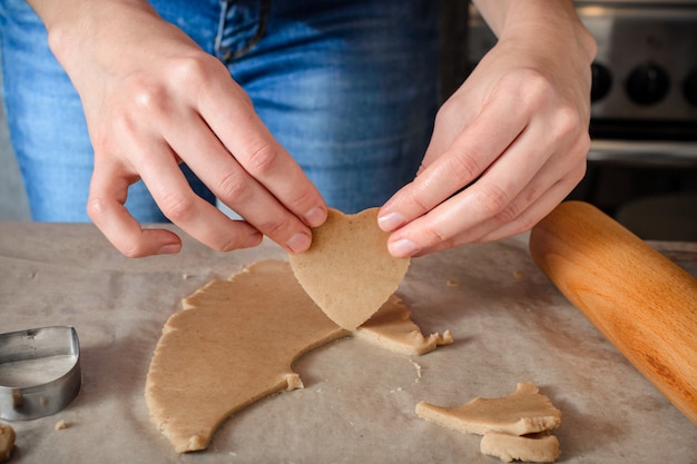 Una mujer joven está cocinando galletas caseras de jengibre.