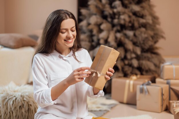 Mujer joven está envolviendo regalos de Navidad para las vacaciones