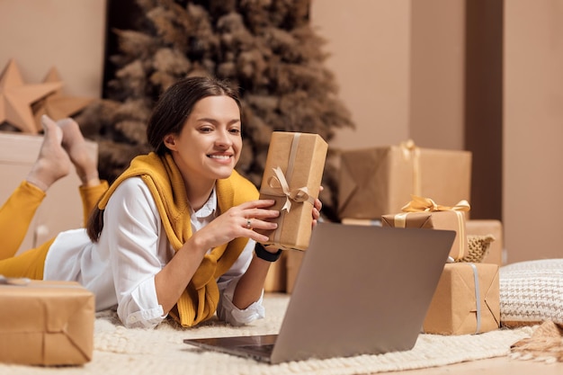 Mujer joven está envolviendo regalos de Navidad para las vacaciones