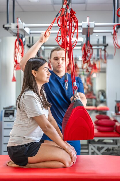 Una mujer joven está haciendo ejercicio con un entrenador personal en un centro de fitness