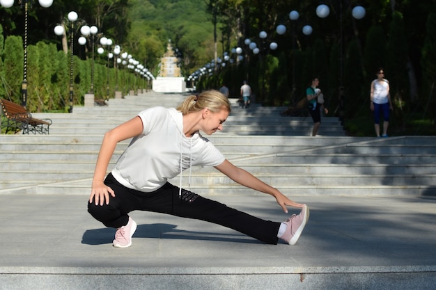 mujer joven está haciendo ejercicio en el muelle en el lago. estilo de vida deportivo activo. gimnasia al aire libre.