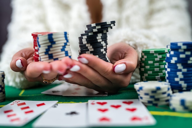 Mujer joven está jugando con éxito en un casino en la mesa con fichas de cartas y alcohol closeup