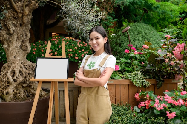 Una mujer joven está sonriendo en el concepto de pequeña empresa de su floristería