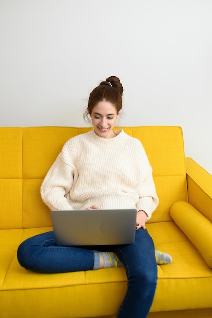 Una mujer joven está usando una computadora portátil para trabajar a distancia o estudiando en línea una foto de alta calidad