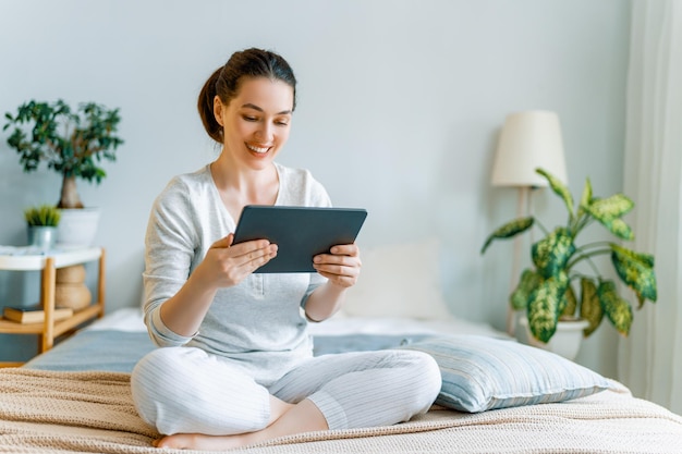 Mujer joven está usando tablet pc para una conversación remota con amigos Chica divertida divirtiéndose