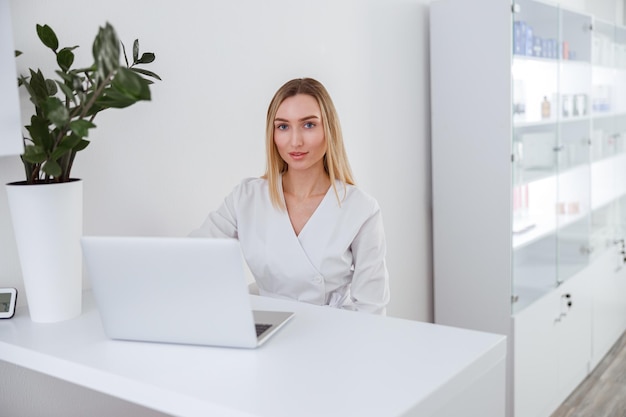 Mujer joven esteticista usando un cuaderno en el trabajo