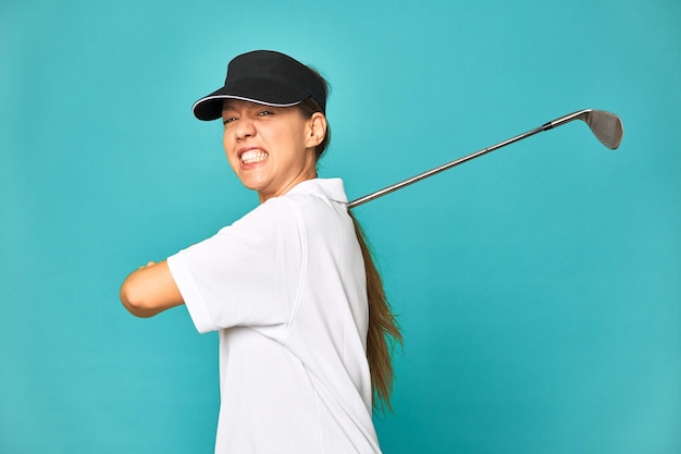 Mujer joven con estilo jugando al golf en el estudio