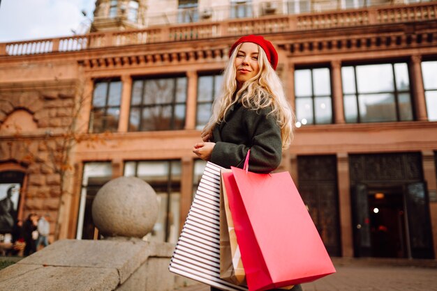 Mujer joven con estilo en ropa de moda con bolsas de compras después de ir de compras Compras de otoño