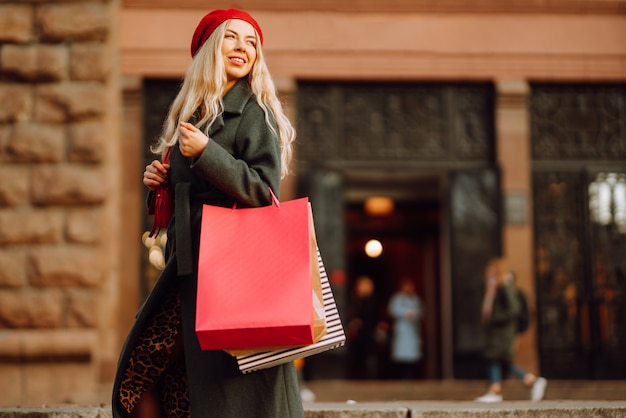 Mujer joven con estilo en ropa de moda con bolsas de compras después de ir de compras Compras de otoño