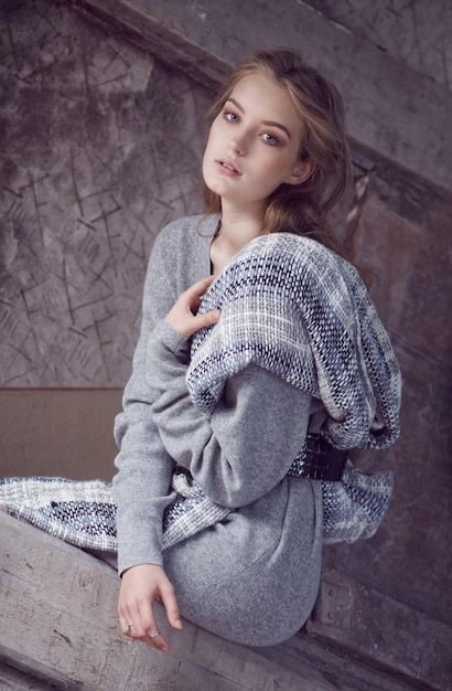 Mujer joven con estilo en un vestido gris largo.