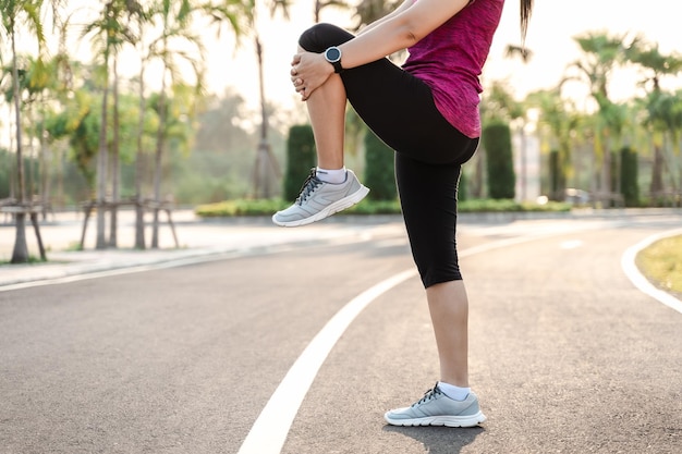 Mujer joven estirando antes de correr Chica deportiva preparándose para correr en el parque