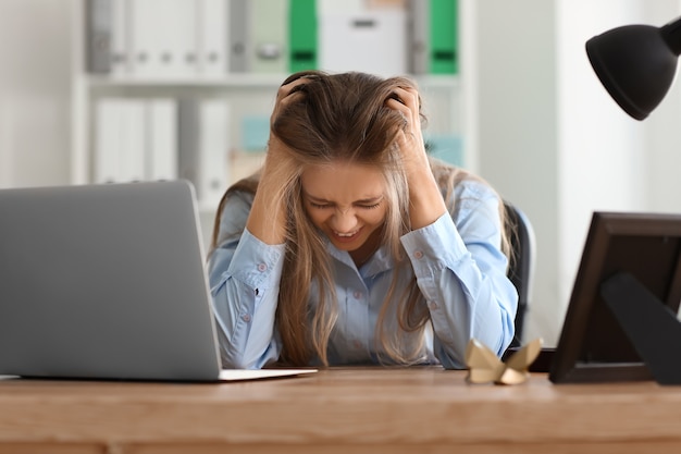 Mujer joven estresada en el lugar de trabajo