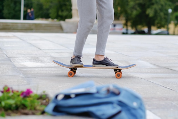 Mujer joven estudia skateboarding en la ciudad