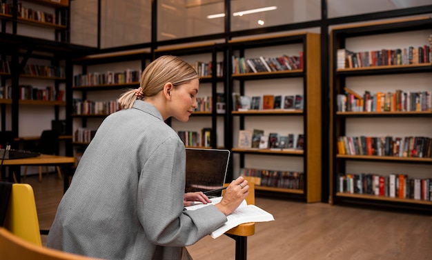 Mujer joven estudiando en la biblioteca