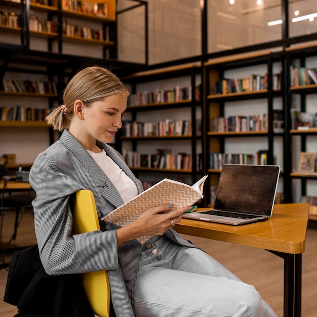 Foto mujer joven estudiando en la biblioteca