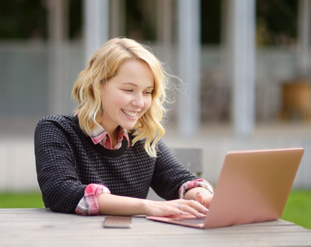 Mujer joven estudiando / trabajando y disfrutando de un hermoso día