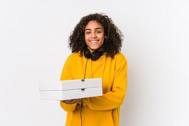 Mujer joven estudiante afroamericana con pizzas riendo y divirtiéndose.