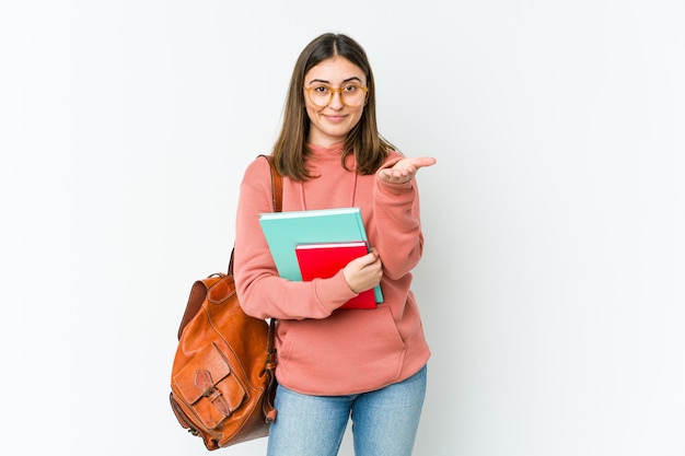 Mujer joven estudiante aislada en blanco bakcground sosteniendo algo con palmas