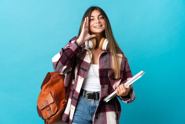 Mujer joven estudiante aislada gritando con la boca abierta