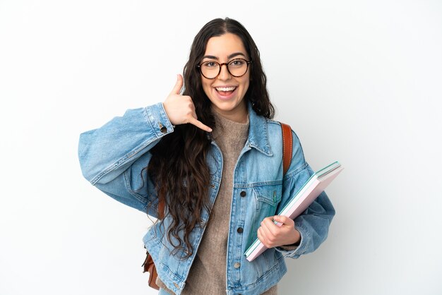 Foto mujer joven estudiante aislada sobre fondo blanco haciendo gesto de teléfono. llámame señal