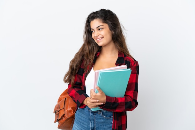 Mujer joven estudiante aislada sobre fondo blanco mirando de lado