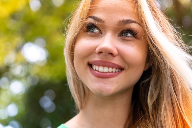 Mujer joven estudiante al aire libre con expresión feliz