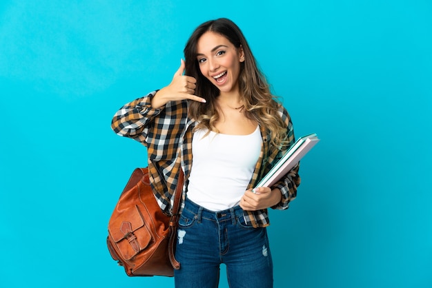 Mujer joven estudiante en azul haciendo gesto de teléfono. Llámame señal