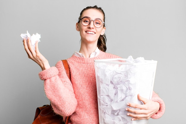 Foto mujer joven estudiante bonita con una basura de bolas de papel de errores