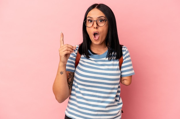 Mujer joven estudiante caucásica con un brazo aislado sobre fondo rosa con una idea, concepto de inspiración.