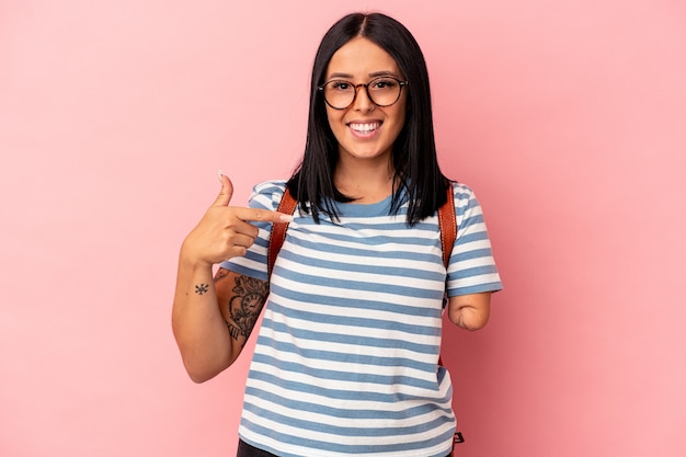 Mujer joven estudiante caucásica con un brazo aislado sobre fondo rosa persona apuntando con la mano a un espacio de copia de camisa, orgulloso y seguro