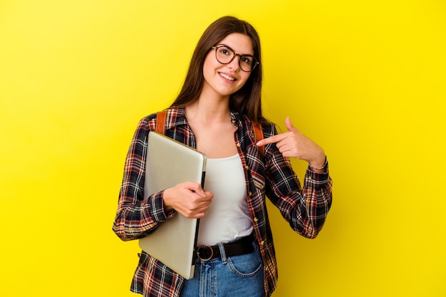 Mujer joven estudiante caucásica sosteniendo un portátil aislado