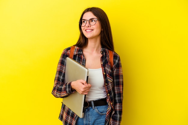 Mujer joven estudiante caucásica sosteniendo un portátil aislado