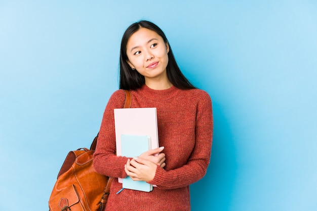 Mujer joven estudiante chino aislada soñando con lograr objetivos y propósitos