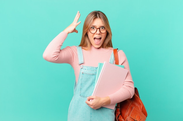 Mujer joven estudiante gritando con las manos en el aire