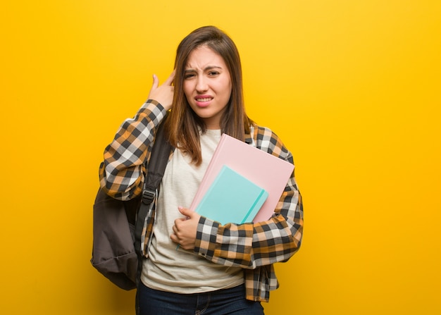 Mujer joven estudiante haciendo un gesto de decepción con el dedo