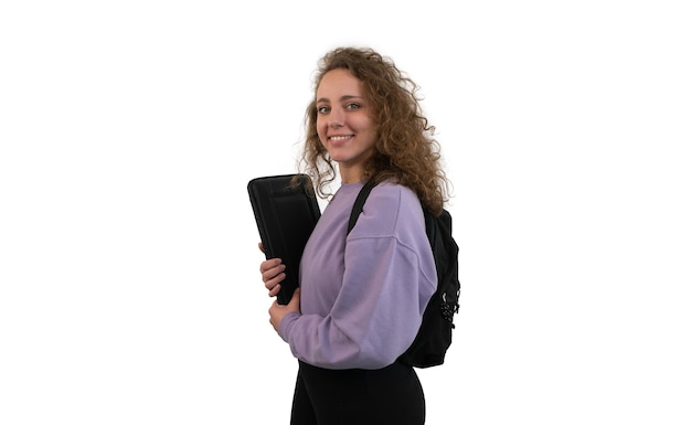 Mujer joven estudiante con una mochila está sosteniendo una computadora