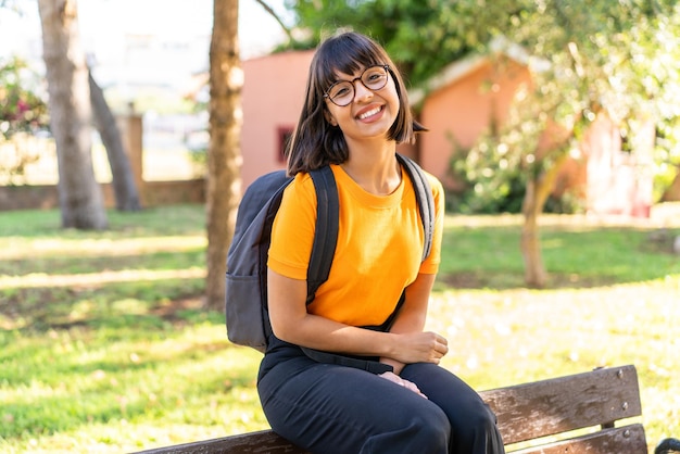 Mujer joven estudiante en un parque. Retrato de un parque con expresión feliz