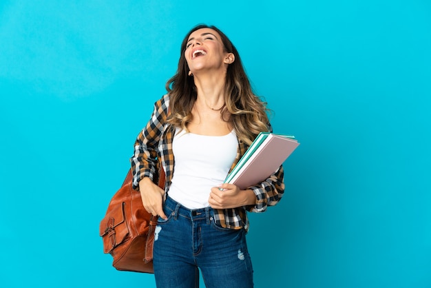 Mujer joven estudiante posando aislada contra la pared en blanco