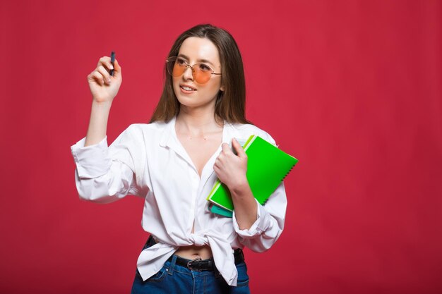 Mujer joven estudiante rizada con gafas sosteniendo libros