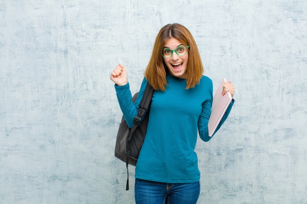 Mujer joven estudiante se siente sorprendida, emocionada y feliz